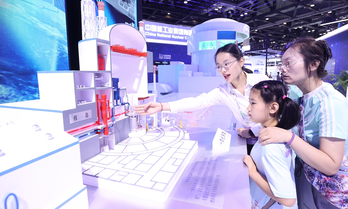 an exhibition staff member (left) introduces an advanced fast reactor nuclear energy system at the china beijing international high-tech expo on july 14, 2024. photo:vcg